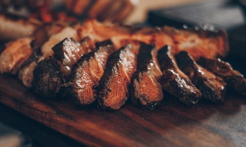 Carne a la parrilla sobre una tabla de madera.