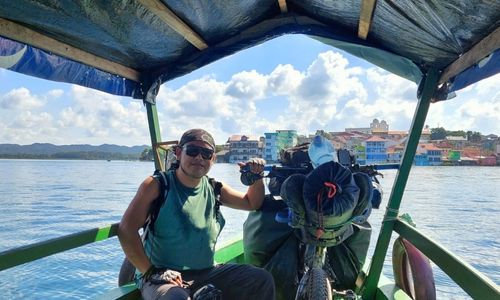 Edgar Az llevando su bicicleta en lancha