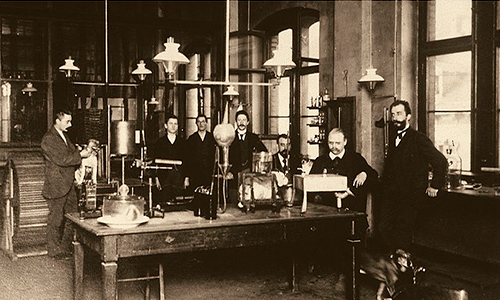 Descripción de foto - Escena del laboratorio y la fábrica con los científicos Friedrich Bayer y Johann Friedrich Weskott. - Crédito de la foto - World . - Crédito de la foto - Bayer Cono Sur