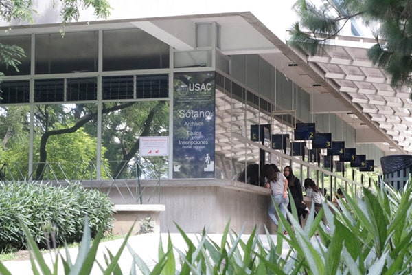 Descripción de la foto: vista del edificio de inscripciones con estudiantes de la USAC realizando pagos. (Crédito: El Sancarlista U)