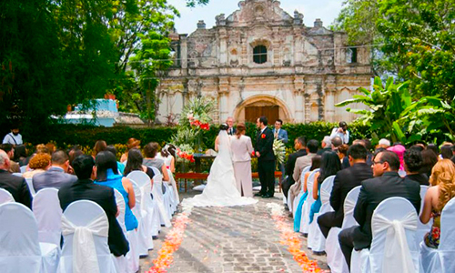Descripción de foto - Boda civil en donde se observan a los invitados y a los novios en medio de las ruinas de Antigua Guatemala. - Crédito de foto - Impacto