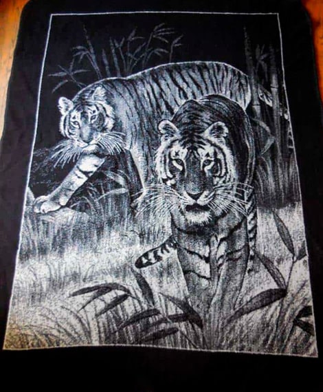 Descripción de foto - Cobertor de empresa San Marcos con una estampa de tigres en colo blanco y de fondo negro. - Crédito de foto - Noticias al día