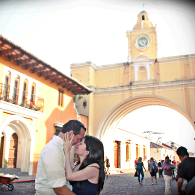 Descripción de foto - Pareja de guatemaltecos frente al arco de la Antigua Guatemala. - Crédito de foto - Creative Solutions GT