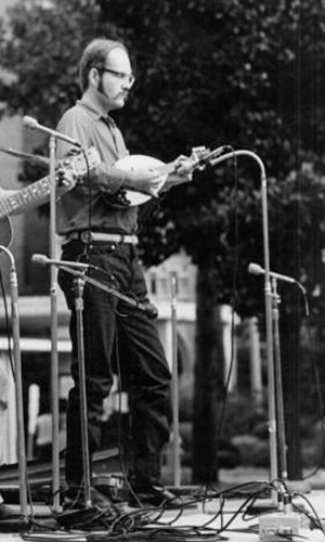 Descripción de foto - Schuster de joven, tocando la mandolinda en un escenario en Estados Unidos. - Crédito de foto - Discogs