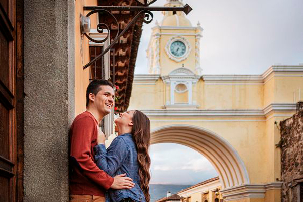 Descripción de foto - joven pareja guatemalteca enamorada frente al Arco de Antigua Guatemala - Crédito de foto - Edgar Ipiña