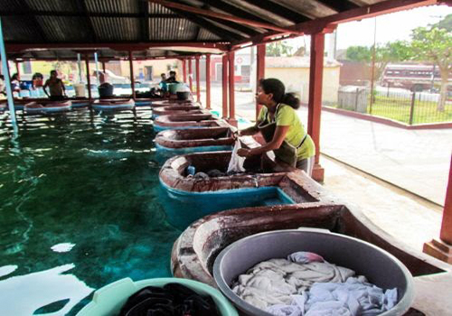 Descripción de foto - mujeres en pila de agua pública lavando su ropa. - Crédito de foto - De paso por_