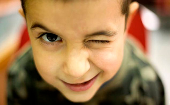 Descripción de foto - niño guiñando el ojo frente la cámara. - Crédito de foto - Ok
