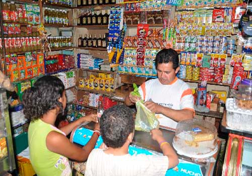 Descripción de foto - tendero atendiendo a niños mientras le compran dulces. - Crédito de foto - Portal Vallenato