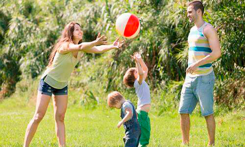 Descripción de la foto para personas con discapacidad visual - Familia jugando zopilote en un jardín. - Crédito de foto - Todo Papás
