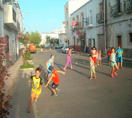 Descripción de la foto para personas con discapacidad visual - Niños corriendo en las calles de unos detrás de otro. - Crédito de foto - Hoy los Ángeles