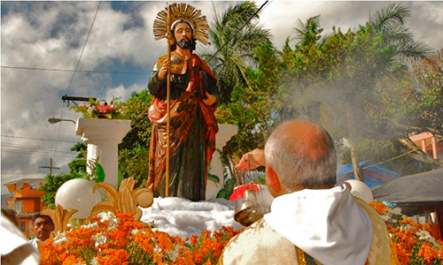 Descripción de la foto para personas con discapacidad visual - Sacerdote bendiciéndo el anda de Santiago Apóstol, patrono de Esquipulas. - Crédito de foto - Esquipilas