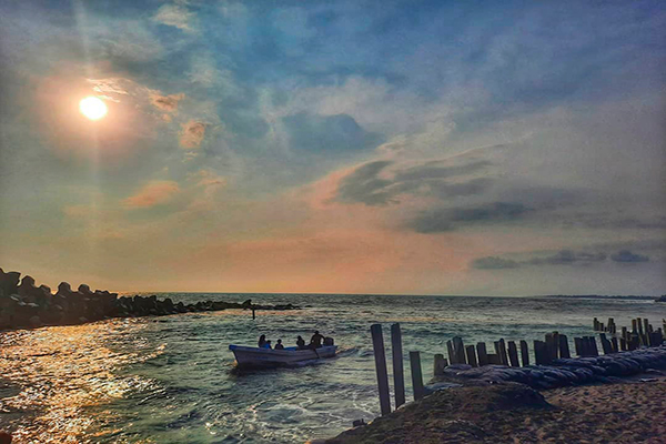 Descripción de la foto para personas con discapacidad visual - Vista de las aguas de la playa de Champerico con unas personas en bote al horizonte. - Crédito de foto - erickwilsoncom